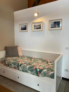 a bed in a room with two pictures on the wall at Villa Onedo in Abbadia Lariana