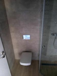 a bathroom with a toilet and a glass shower at Hotel Merlot in Eger