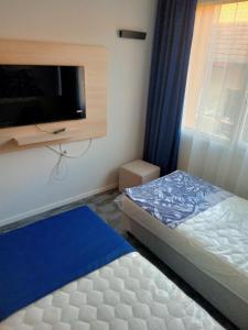 a bedroom with a bed and a flat screen tv at Hotel Merlot in Eger