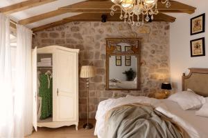 um quarto com uma cama, um espelho e um lustre em Vivaldi em Dubrovnik