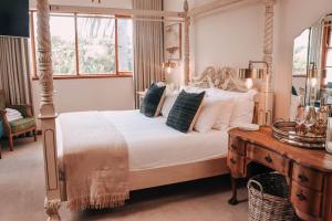 1 dormitorio con cama con dosel y mesa de madera en Sonnekus Boutique Hotel & Bistro en St James