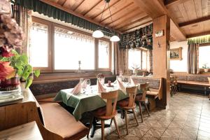 un ristorante con tavolo, sedie e finestre di Gasthof Pension Berghof a Hippach Altre 30 foto