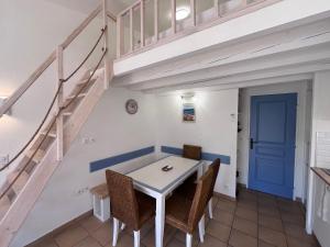 uma sala de jantar com uma mesa e cadeiras e uma escadaria em Charmant appartement Village Restanques de Saint Tropez em Grimaud