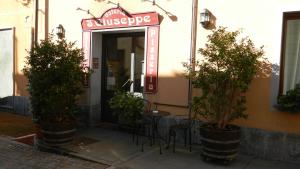 a entrance to a restaurant with a table and potted trees at Osteria San Giuseppe in Ceriano Laghetto