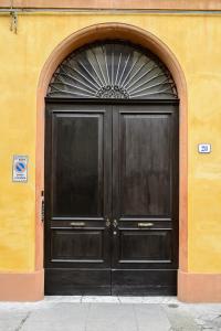 uma grande porta preta num edifício amarelo em TIFFANY TORTELLINOSUITE Modena em Módena