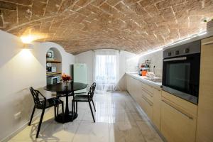 eine Küche und ein Esszimmer mit einem Tisch und Stühlen in der Unterkunft TIFFANY TORTELLINOSUITE Modena in Modena