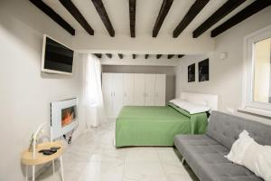 ein Wohnzimmer mit einem grünen Bett und einem Sofa in der Unterkunft TIFFANY TORTELLINOSUITE Modena in Modena