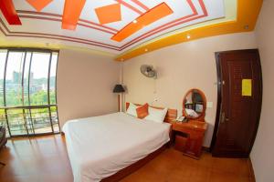 Schlafzimmer mit einem weißen Bett und einem Spiegel in der Unterkunft Vân Hà Hotel Lào Cai - by Bay Luxury in Lào Cai