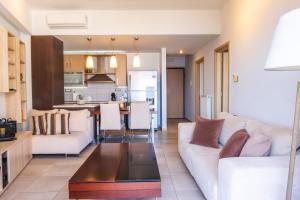 a living room and kitchen with a white couch at Filia Home in Agios Nikolaos