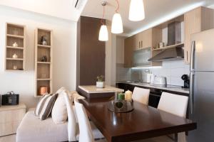 a kitchen with a dining table and a refrigerator at Filia Home in Agios Nikolaos