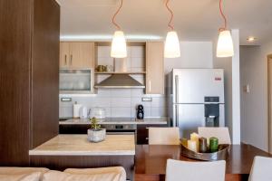 a kitchen with a table and a refrigerator at Filia Home in Agios Nikolaos