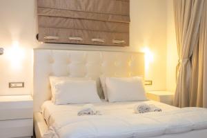 a white bed with white sheets and pillows at Filia Home in Agios Nikolaos +6 photos