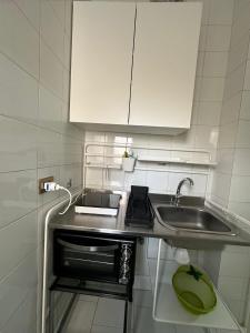 una piccola cucina con lavandino e armadietto bianco di Gioia Guest House a Torre del Greco