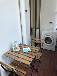 a wooden table in a room with a washing machine at Gioia Guest House in Torre del Greco