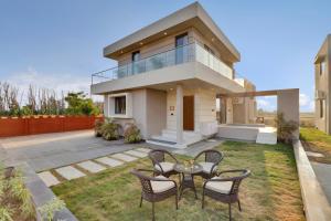 a house with a table and chairs in the yard at Goverdhan Greens Resort in Dwarka