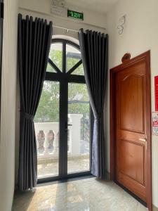 een open deur met zwarte gordijnen in een kamer bij Minh Phương Hotel - Khách sạn Thủ Dầu Một Bình Dương in Xóm Ông Phùng