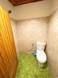 a bathroom with a toilet and a green floor at จันทวี รีสอร์ท in Changwat Prachuap Khiri Khan