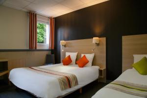 Habitación de hotel con 2 camas y almohadas de color naranja y verde. en The Originals City, Le Clos de l'Orgerie, Laval Sud (Inter-Hotel), en Château-Gontier