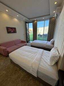 a hotel room with two beds and a couch at ريزا in Al Madinah