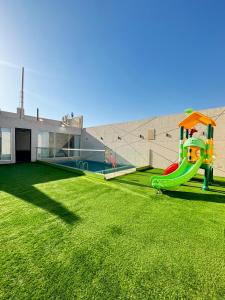 un gran patio con un parque infantil con un tobogán en ريزا en Medina