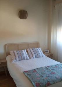 een slaapkamer met een bed met een deken erop bij Casa Rural "Estrella", El Ronquillo, 2 dormitorios, 2 adultos y 2 niños in Sevilla
