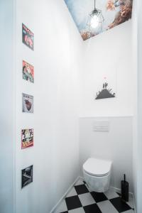 a bathroom with a white toilet and a checkered floor at Św. Antoniego in Wrocław