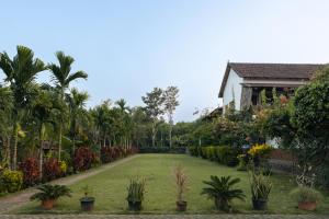 a garden in front of a house at Balkatmane Heritage Spa Resort Udupi in Udupi