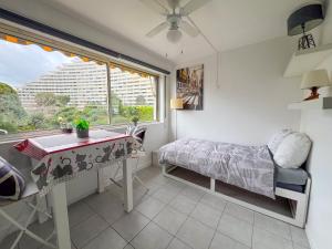 - une chambre avec une table, un lit et une fenêtre dans l'établissement La Studette Marina 06, à Villeneuve-Loubet