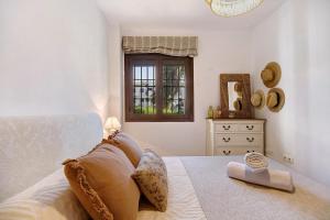 ein Schlafzimmer mit einem Bett, einem Fenster und einer Kommode in der Unterkunft Apartamento en Playa de La Barrosa in Chiclana de la Frontera + 20 Fotos