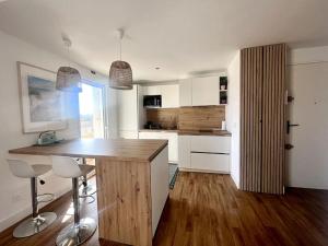 a kitchen with a wooden counter and white cabinets at Appartement Palavas les flots 4 personnes in Palavas-les-Flots