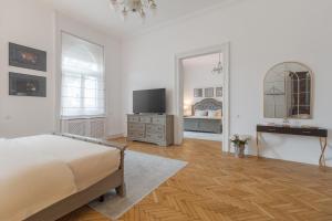 a white bedroom with a bed and a tv at UNIQUE EXPERIENCE at Rimanóczy Palace Oradea in Oradea