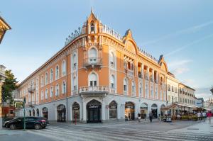 a large building on a street with a car parked in front at UNIQUE EXPERIENCE at Rimanóczy Palace Oradea in Oradea
