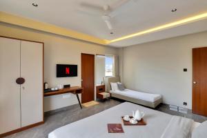 Habitación de hotel con cama y escritorio en Goverdhan Greens Resort, en Dwarka