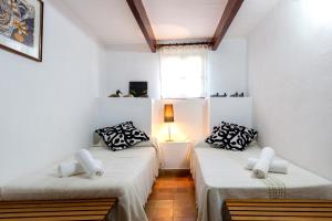 ポリェンサにあるVilla Plana Morroの白い壁の客室で、ベッド2台、窓が備わります。