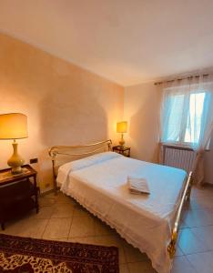 een slaapkamer met een bed, 2 lampen en een raam bij Comfortable apartment in tuscan wine farm in Montecarlo