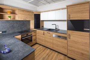 a large kitchen with wooden cabinets and a sink at Ferienwohnungen Scheifler in Berchtesgaden