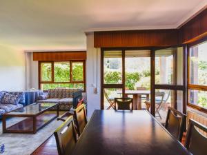 een woonkamer met een tafel en een bank bij Cómodo y espacioso chalet con piscina comunitaria in Miengo