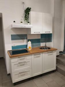 a kitchen with white cabinets and a sink at Urban Chic Guest House free Wi-Fi- in Salerno