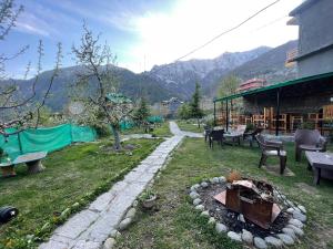 a backyard with a fire pit in the grass at heavens retreat manali in Manāli
