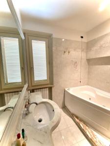 een badkamer met een bad, een toilet en een wastafel bij Comfortable apartment in tuscan wine farm in Montecarlo