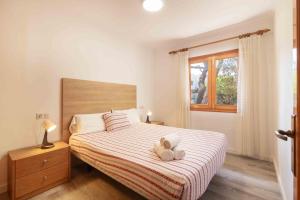 a bedroom with a bed with a teddy bear on it at Canta in Playa de Muro