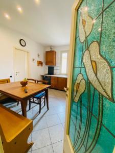 een keuken en eetkamer met een tafel en een glazen deur bij Comfortable apartment in tuscan wine farm in Montecarlo