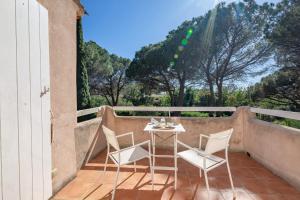 un patio avec une table et des chaises sur un balcon dans l'établissement Le Mas des Oliviers - Welkeys, à La Croix-Valmer