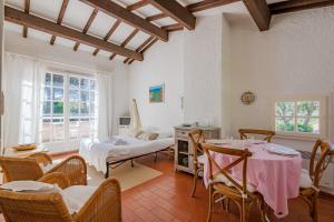 une chambre avec deux lits, une table et des chaises dans l'établissement Le Mas des Oliviers - Welkeys, à La Croix-Valmer 7 autres photos