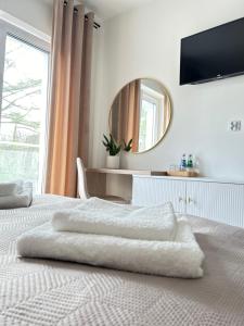 biała sypialnia z 2 łóżkami i lustrem w obiekcie Rezydencja Leśniów w mieście Żarki