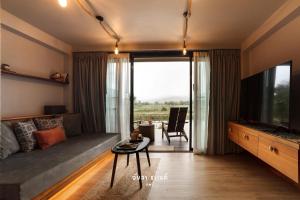 ein Wohnzimmer mit Sofa und Fernseher in der Unterkunft Ayla Chalet in Phrae
