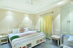 a bedroom with a bed and a chair and a window at Hotel Pinky Villa - Paharganj I New Delhi Railway Station in New Delhi