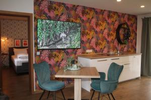 una habitación con mesa y sillas y un dormitorio en Bayern Resort Hotel (Adults only), en Grainau