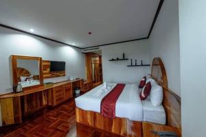 a bedroom with a bed and a vanity and a mirror at Sky View Hotel Buriram in Buriram