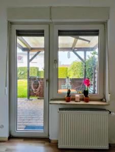 an open door to a patio with two windows at Modern cozy apartment, green neighborhood, good connectivity in Duisburg